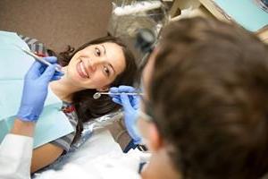 Dental patient in chair looking up at dentist